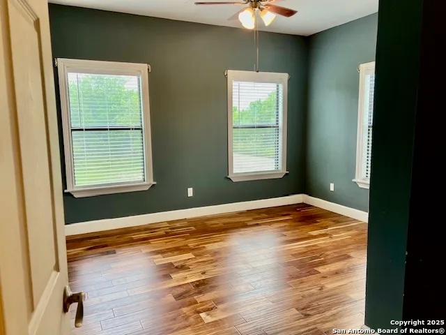 a view of empty room with window and wooden floor