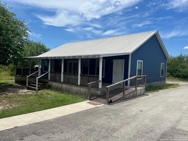 a view of house with backyard and glass door