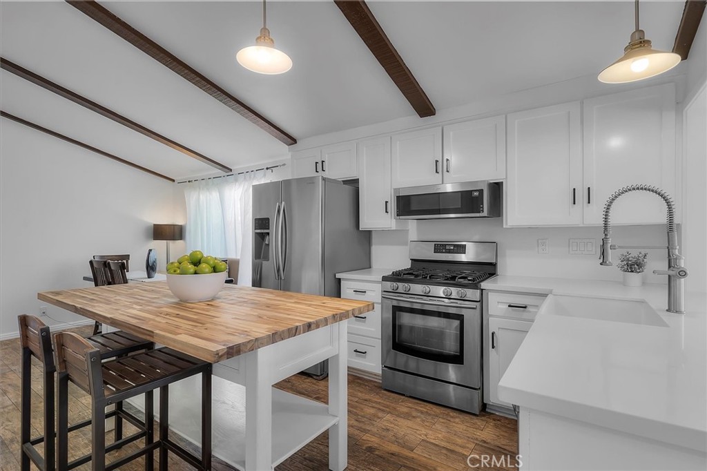 1702 East Dimondale Drive Carson, CA 90746 - Photo 16 of 43 a kitchen that has a table chairs stainless steel appliances and wooden floor