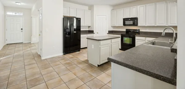 a kitchen with stainless steel appliances granite countertop a sink a stove a microwave a counter top space and cabinets