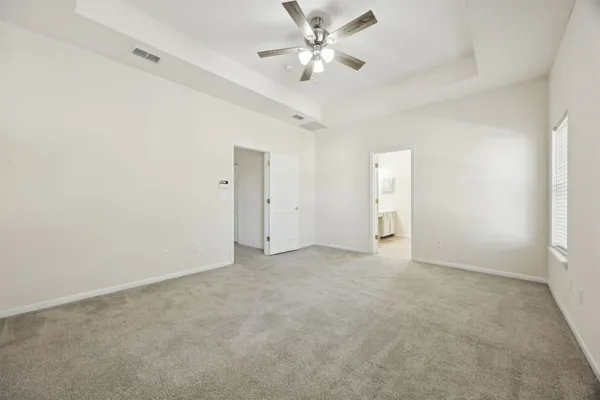 an empty room with a ceiling fan and a window