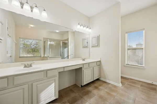 a bathroom with a sink double vanity granite and a mirror