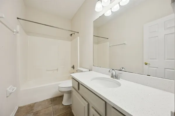 a bathroom with a granite countertop sink a toilet and shower