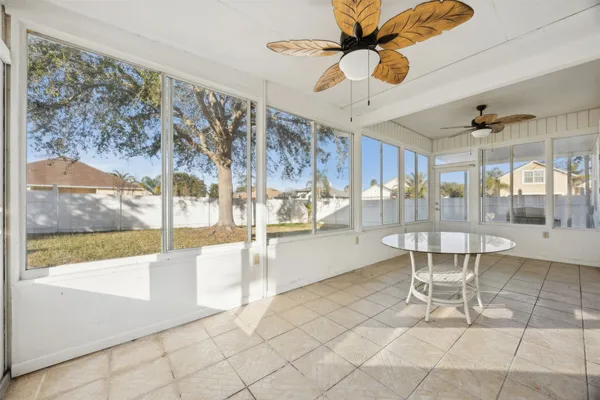 a dining room with wooden floor and a floor to ceiling window