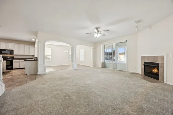 an empty room with windows and fireplace