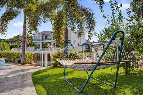 a view of a house with fountain and a flower garden