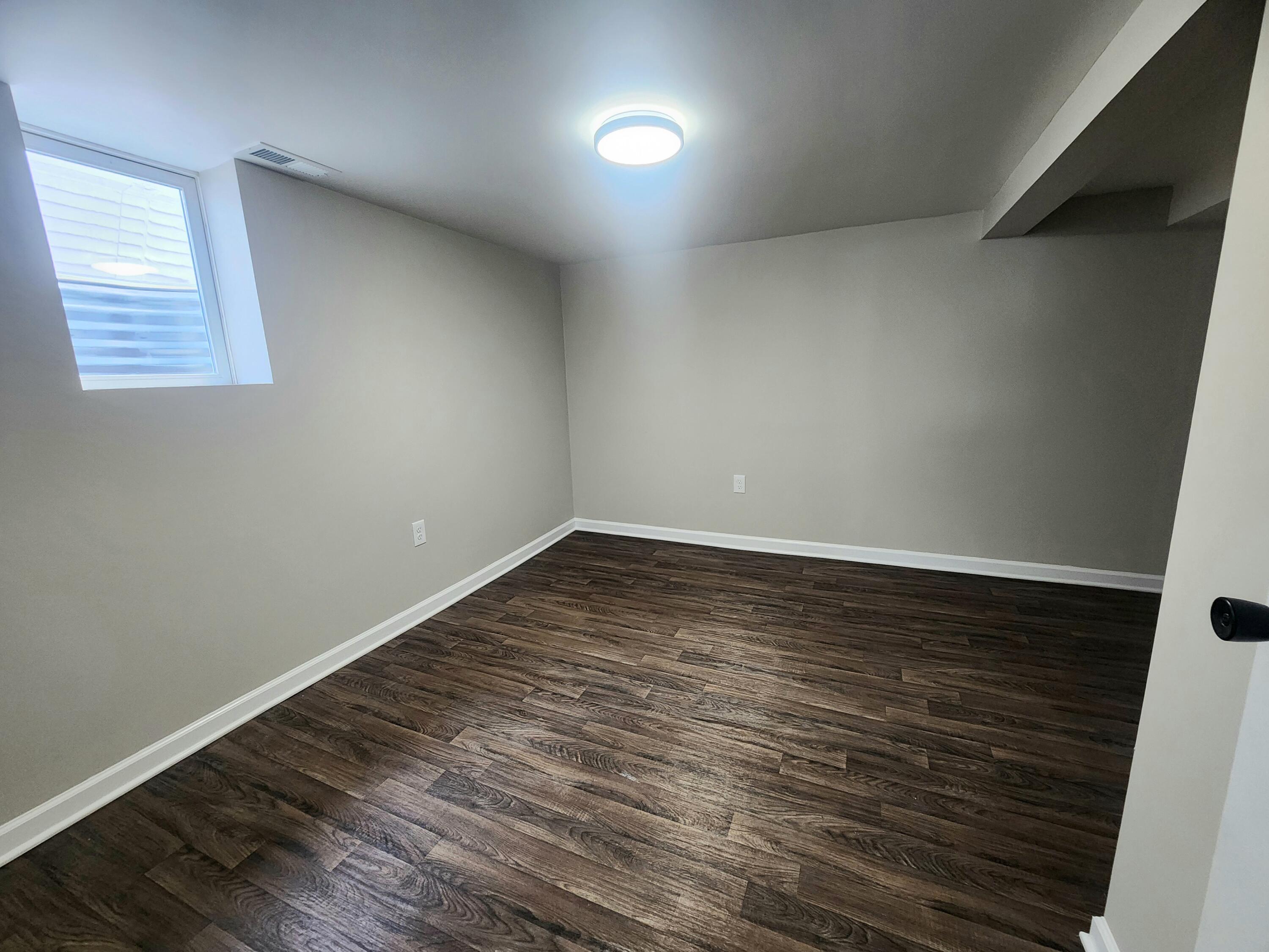 601 Burr Street Gary, IN 46406 - Photo 18 of 24 an empty room with wooden floor and windows