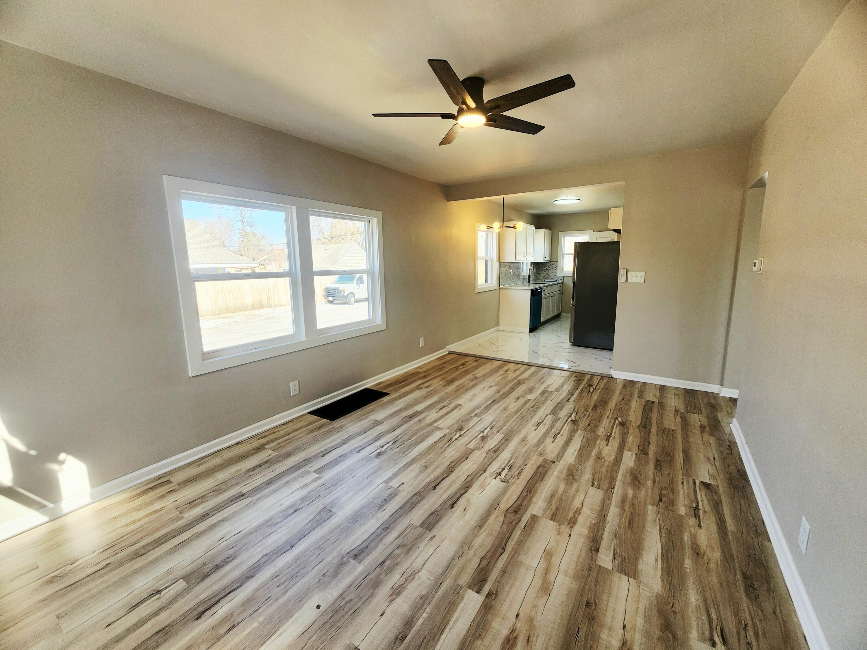 601 Burr Street Gary, IN 46406 - Photo 6 of 24 a view of a room with wooden floor ceiling fan and window