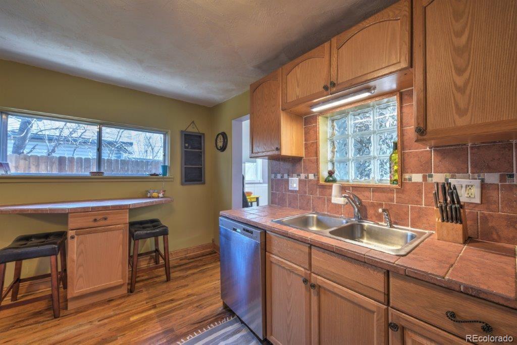 508 East Baseline Road Lafayette, CO 80026 - Photo 9 of 35 a kitchen with stainless steel appliances granite countertop a sink a stove cabinets counter space and a window