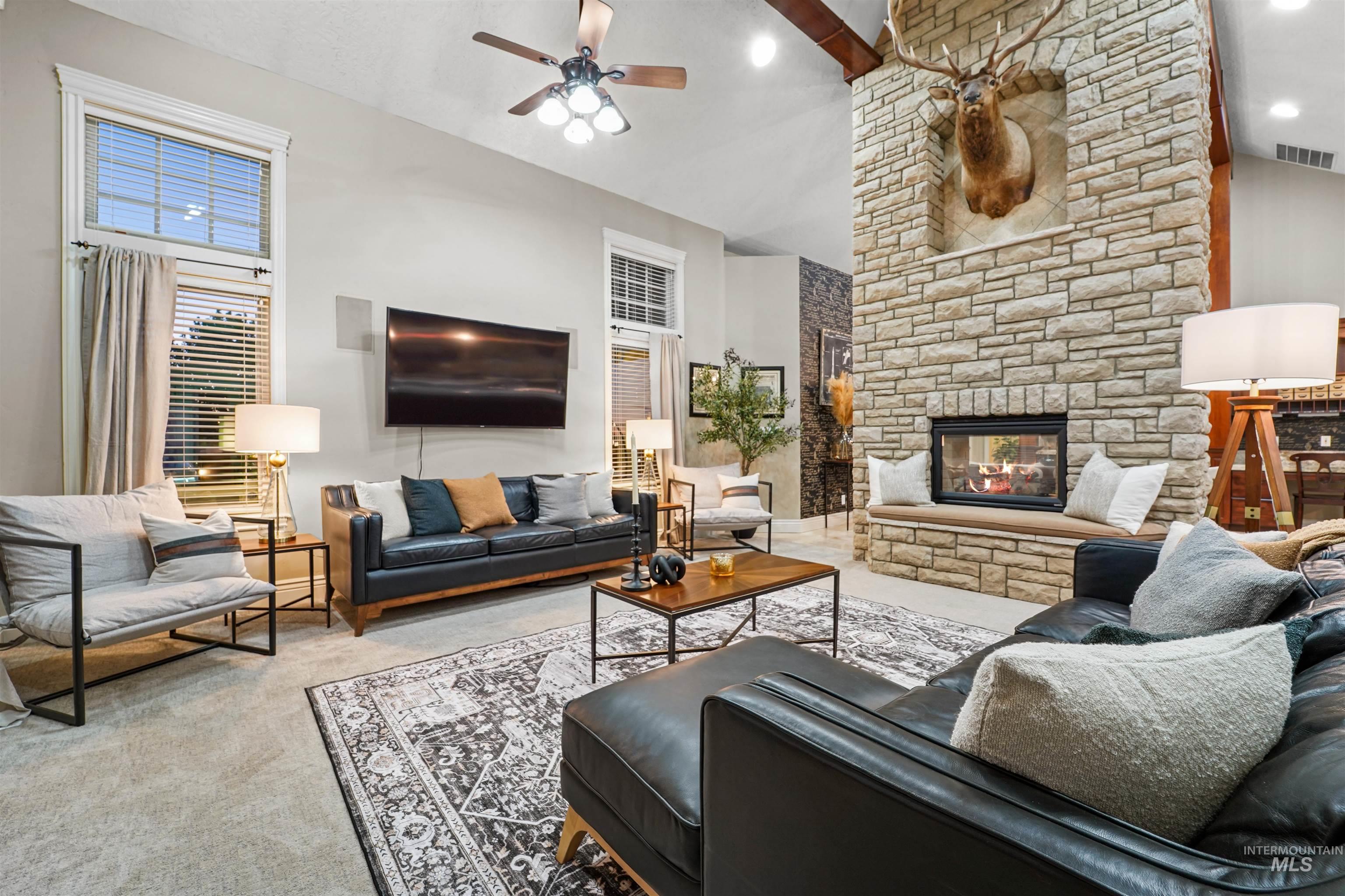 10430 Randall Lane Caldwell, ID 83607 - Photo 13 of 39 Living room featuring carpet, a ceiling fan, a fireplace, and high vaulted ceiling
