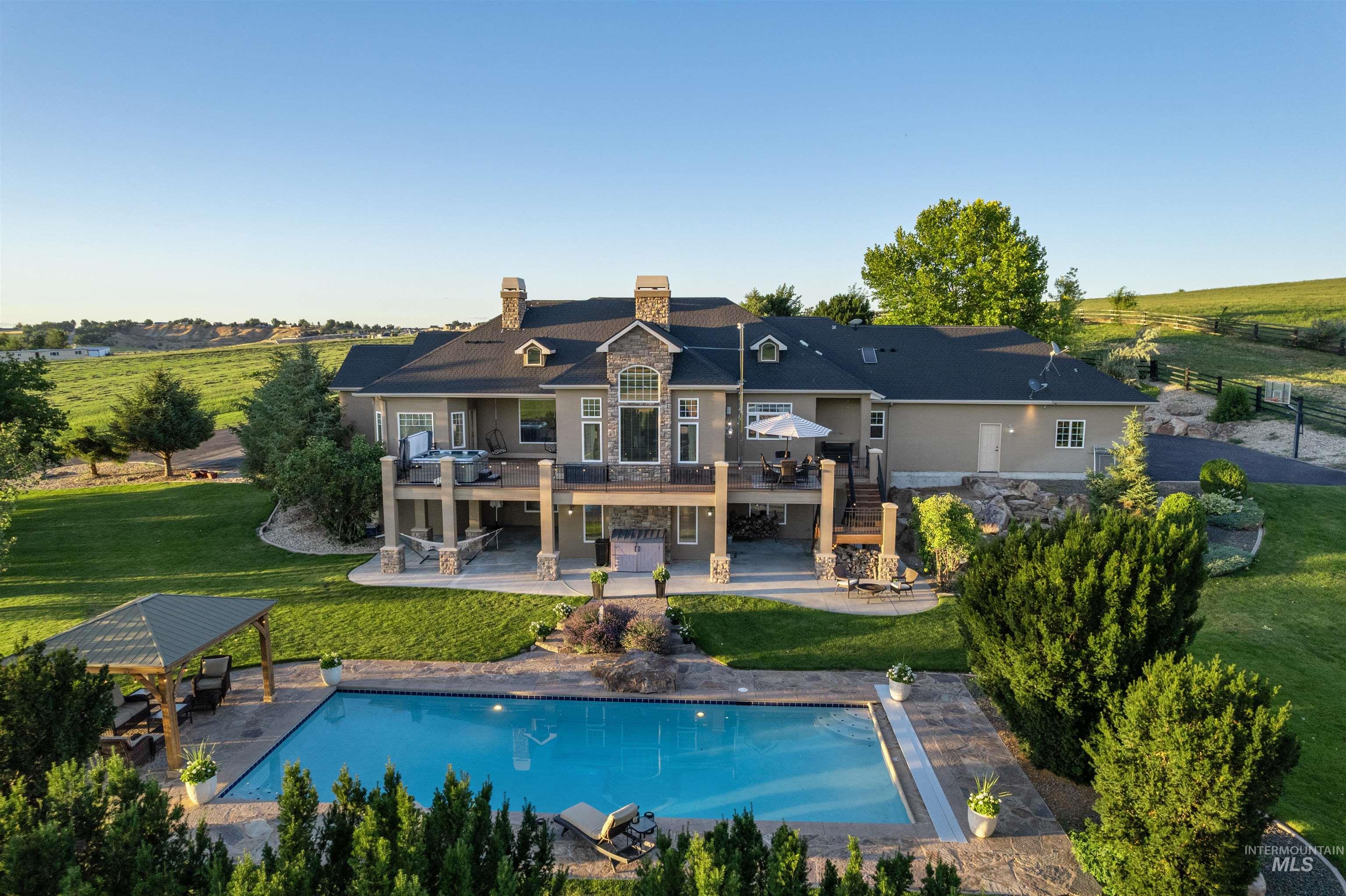 10430 Randall Lane Caldwell, ID 83607 - Photo 5 of 39 Back of property featuring stairway, a wooden deck, a chimney, a patio, and a lawn