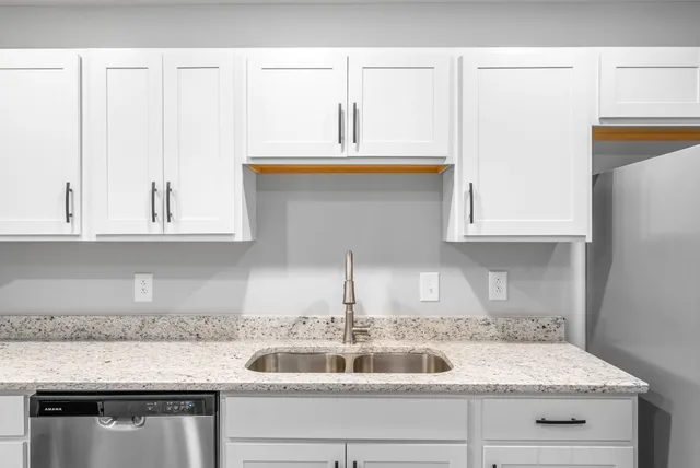 a kitchen with granite countertop a sink and cabinets