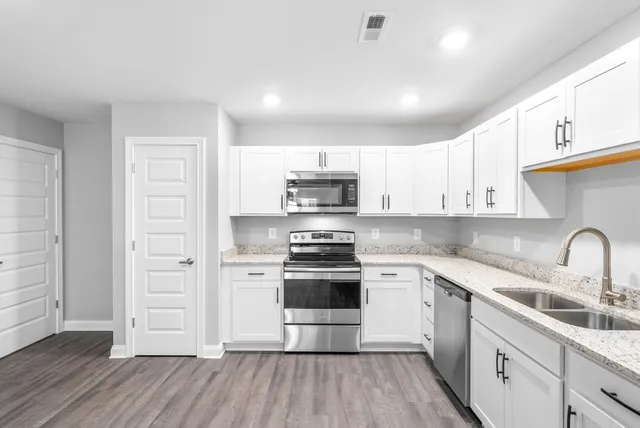 a kitchen with stainless steel appliances granite countertop a stove and a sink