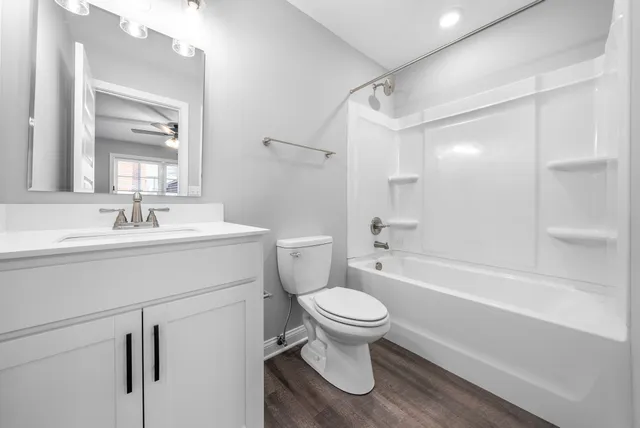 a bathroom with a sink toilet vanity and shower
