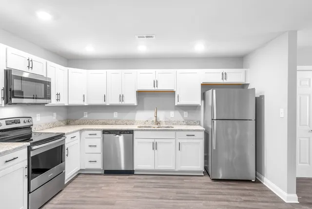 a kitchen with stainless steel appliances granite countertop a stove a refrigerator and a microwave