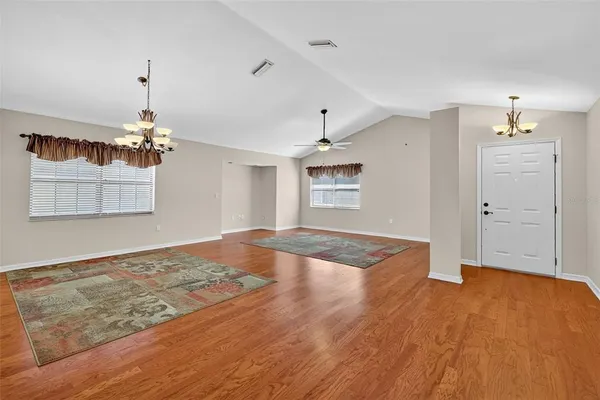 a view of a livingroom with wooden floor and a ceiling fan