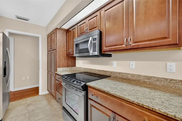 a kitchen with granite countertop cabinets stainless steel appliances and a counter top space
