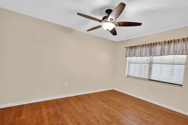 a view of a room with a ceiling fan and wooden floor