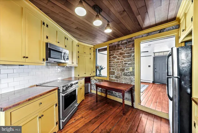 a kitchen with stainless steel appliances granite countertop a stove and a wooden floors