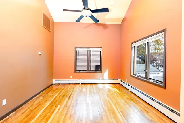 a view of a room with wooden floor and a window