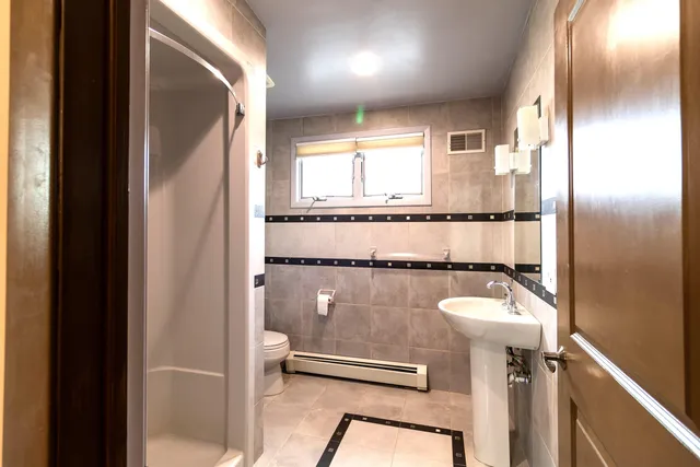 a bathroom with a toilet mirror vanity and tub