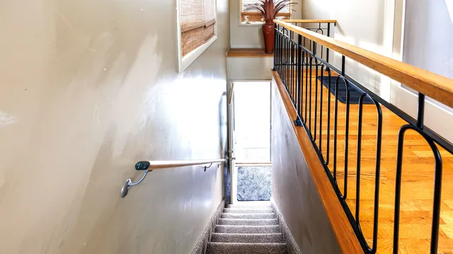 a view of staircase with wooden floor and next to a window