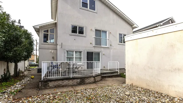 a view of a house with a small yard and wooden fence