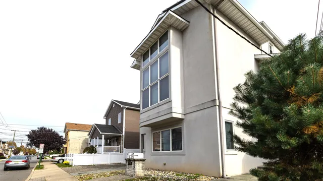 a city view with tall buildings and cars parked on road