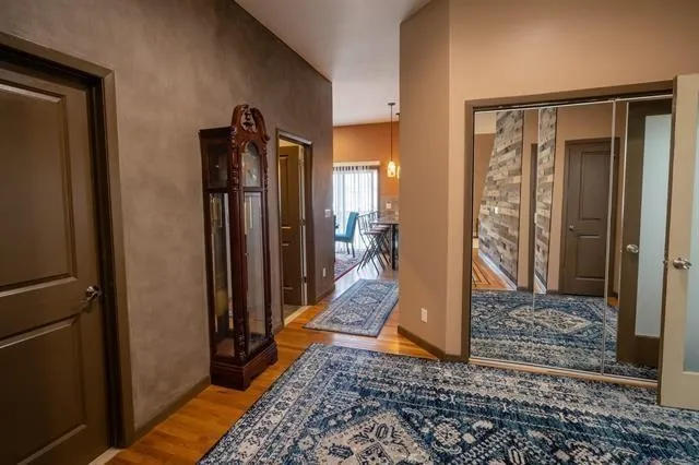 a kitchen with stainless steel appliances granite countertop a refrigerator a stove and a dining table with wooden floor