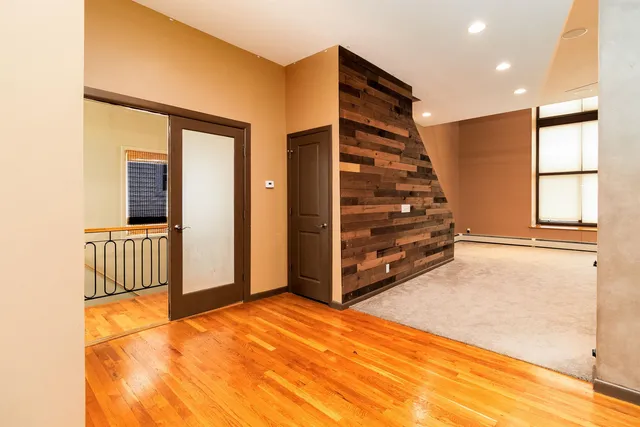 a view of an empty room with stairs and a window