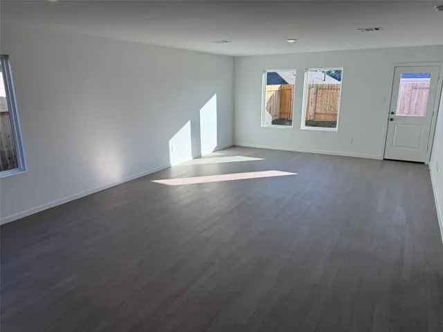 an empty room with windows and fireplace