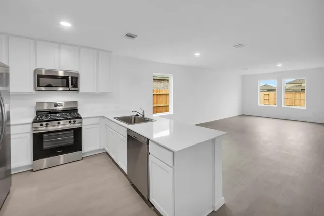 a kitchen with stainless steel appliances a stove sink microwave and refrigerator