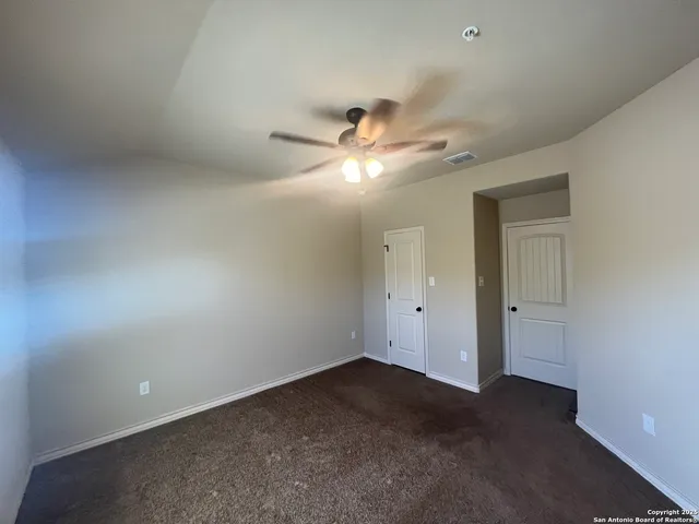 an empty room with a ceiling fan and a window