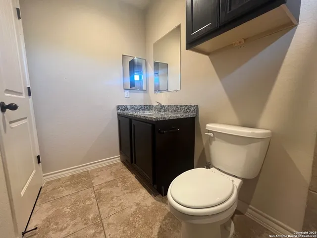 a bathroom with a granite countertop toilet and a sink