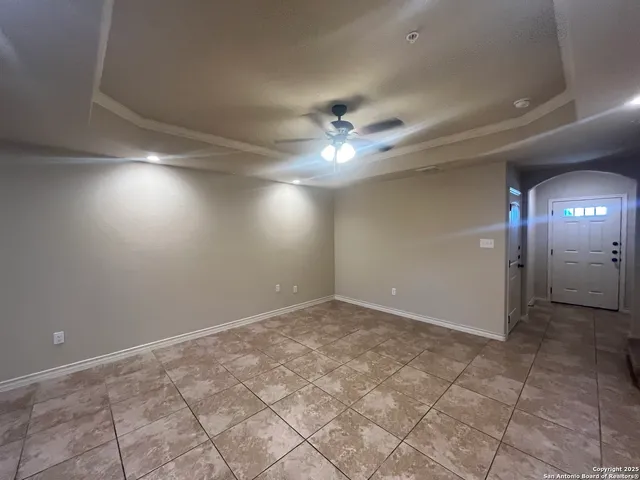 an empty room with a ceiling fan and bathroom