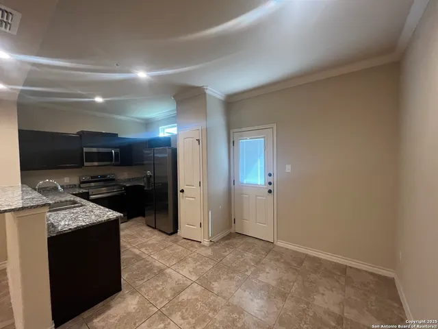 a kitchen with stainless steel appliances kitchen island granite countertop a refrigerator and a sink