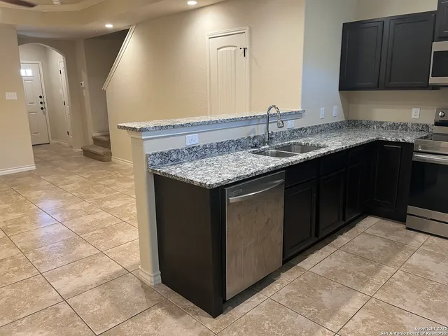 a kitchen with granite countertop a sink and a stove