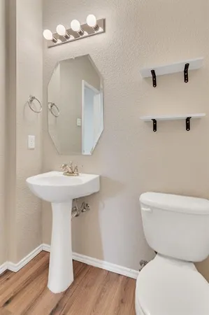 a bathroom with a toilet sink and mirror