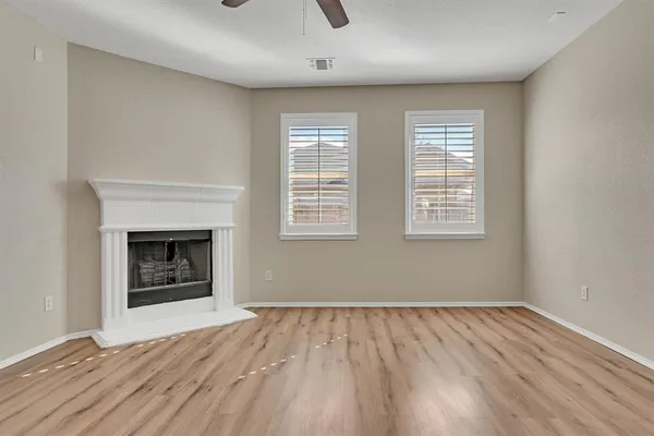 a view of an empty room with a window and fireplace