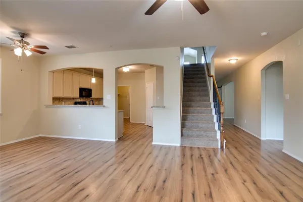 a view of a room with wooden floor and ceiling fan
