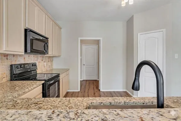 a kitchen with stainless steel appliances granite countertop a stove a sink and a microwave