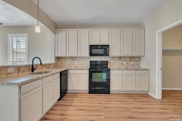 a kitchen with a sink stove and cabinets