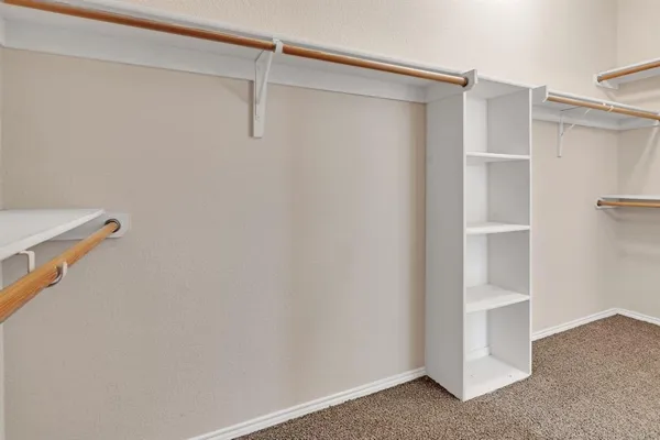 a view of walk in closet with empty racks