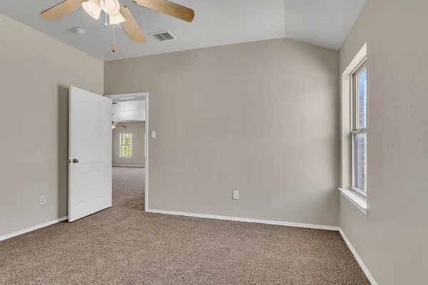 an empty room with a ceiling fan and a window