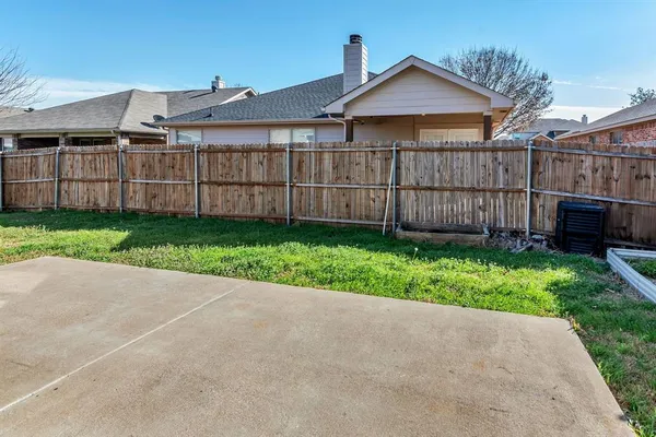 a view of a small yard and wooden fence