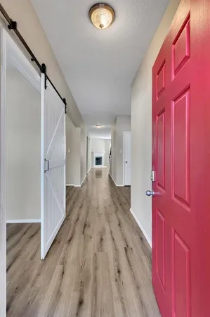 a view of a hallway with wooden floor and staircase