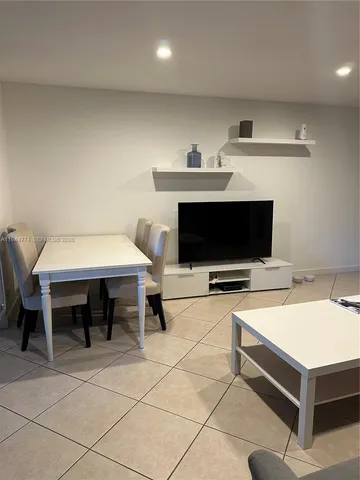 a living room with furniture a flat screen tv and a table