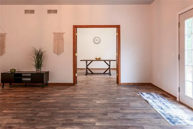 a view of a room with wooden floor and furniture