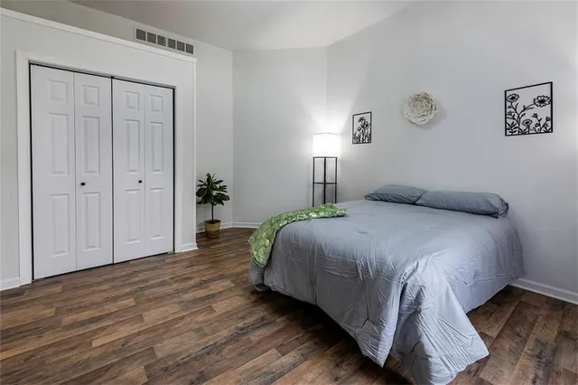 a bedroom with a bed and painting on the wall