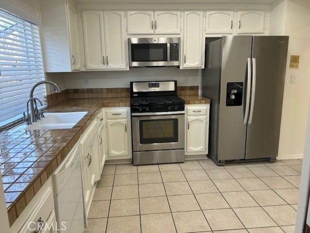 a kitchen with stainless steel appliances granite countertop a stove a refrigerator and a sink